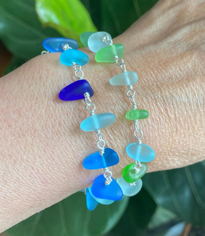 Sterling silver sea glass bracelet with blue and green wire-wrapped sea glass beads on wrist