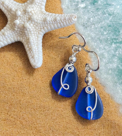 Wire wrapped handmade blue sea glass earrings in sterling silver with beach-inspired dangling design